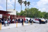 Estudiantes permanecen afuera de una escuela en Tamaulipas mientras elementos de la Guardia Estatal resguardan el acceso ante una alerta.