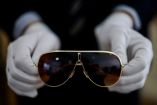 Gafas aviador de Michael Jackson sostenidas con guantes blancos durante presentación previa a subasta en Aguttes, Francia, abril de 2026