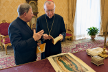 El cardenal Pietro Parolin revisa un ejemplar del libro La práctica de la presencia de Dios junto a un sacerdote en una sala del Vaticano