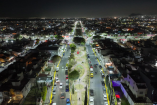 Vista aérea nocturna de Ecatepec con avenidas iluminadas, camellones y viviendas tras el programa de alumbrado público.