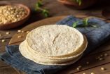 Pila de tortillas de maíz nixtamalizado sobre una servilleta azul, alimento que aporta hierro, ácido fólico y calcio durante el embarazo.