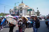Maestros de la CNTE con sombrillas marchan hacia la Secretaría de Gobernación