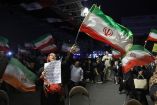 Iraníes ondean banderas de su país en Teherán.