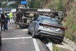 Automóvil sedán gris chocado y camioneta de carga volcada sobre la cinta asfáltica tras un choque múltiple en la carretera Apizaco-Tlaxcala, a la altura del letrero a Tizatlán. Elementos de la Guardia Nacional resguardan el área.