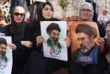 Mujeres iraníes sostienen retratos de Mojtaba Jamenei.