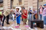 Clara Brugada, jefa de Gobierno de la CDMX, barriendo con agua y jabón una calle del Centro Histórico junto a ciudadanos y comerciantes durante un tequio de limpieza.