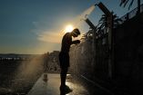 Un hombre se ducha en la playa