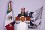 otografía de la Presidenta de México, Claudia Sheinbaum, hablando desde el atril presidencial durante la Conferencia del Pueblo, acompañada de la bandera de México.