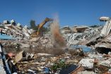 Una excavadora con pinza trabaja en la zona de un edificio derrumbado tras los terremotos del 24 de junio en La Guaira, Venezuela.