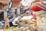 Una venezolana camina entre los escombros de un edificio destruido por los sismos.