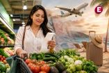 Consumidora mexicana revisa su recibo frente a un carrito con frutas y verduras, mientras un avión y una playa representan el aumento en los costos vacacionales.