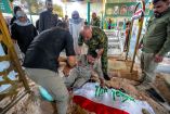 Una persona que asiste al funeral reacciona junto a la tumba —cubierta con la bandera de Irak— de Hussein Abbas al-Tamimi