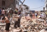 Hombre cargando una caja con escombros durante las labores de limpieza por el temblor en Colombia.