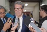 Ricardo Monreal responde preguntas de reporteros durante una entrevista en un pasillo, acompañado por otros asistentes y varios micrófonos.