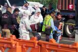 Peritos forenses y elementos de la Fiscalía trasladando un cuerpo en una camilla tras un incidente de seguridad.