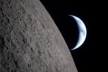 La Luna ocupa el primer plano mientras la Tierra aparece parcialmente iluminada al fondo, fotografiada desde la nave Orion.