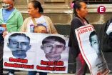 Familiares de los normalistas desaparecidos de Ayotzinapa sostienen lonas con los rostros de Doriam y Jorge Luis González Parral previo a su reunión en Palacio Nacional.