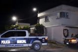 Policías resguardan una vivienda atacada en Tlamaco, Atitalaquia, Hidalgo, durante la noche, con cinta de seguridad frente al inmueble.