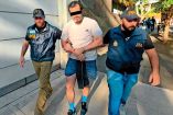 Fernando Farías esposado y custodiado por autoridades.