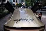 Tesla Cybercab exhibido en Austin, Texas, con sus puertas abiertas mientras una fotógrafa registra el vehículo autónomo.