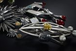 Broches de joyería mexicana en plata, con formas orgánicas, piedras de colores y detalles florales sobre un fondo negro.