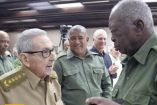Hombre mayor con uniforme verde olivo conversa con un militar durante un acto del Ministerio del Interior en Cuba.