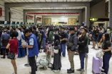 Pasajeros esperan con equipaje en el aeropuerto de Yakarta tras las interrupciones de vuelos por la ceniza volcánica del Anak Krakatoa.
