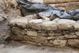 Restos arqueológicos de la posible muralla de Lutecia gala aparecen durante una excavación en el centro de París, con piedras y tierra expuestas.