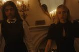Dos brujas aparecen frente a un espejo y candelabros encendidos en una escena de American Horror Story 13.