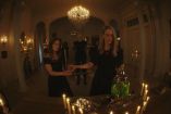 Brujas de Miss Robichaux realizan un ritual rodeadas de velas dentro de la academia en AHS 13.