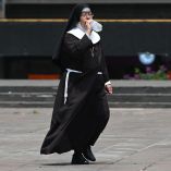 CIUDAD DE MÉXICO, 09JUNIO2024.- Una monja camina por la calle bebiendo agua de una botella para mitigar el calor. FOTO: DANIEL AUGUSTO/ CUARTOSCURO.COM