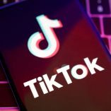 Imagen de un teléfono sobre el teclado de una computadora y con el logo de TikTok