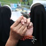 Una persona con un rosario en la mano