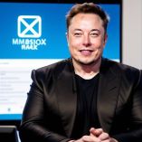 Elon musk sonriendo frente a su correo electrónico.
