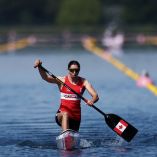 Katie Vincent remando hacia la meta, con el remo dentro del agua y la mirada enfocada en la línea