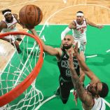 Derrick White encestando en una colada.