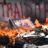 Retrato enmarcado de Alfonso Cepeda Salas, dirigente del SNTE, arde en medio de papeles, cables y escombros incendiados tras la irrupción violenta de la CETEG en las oficinas sindicales ubicadas en la calle República de Venezuela, en la Ciudad de México. En el fondo, se distingue la palabra “TRAIDOR” pintada con aerosol rojo en la pared.