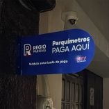 Letrero atornillado a una pared en donde se dan indicaciones de parquímetros