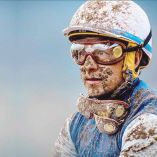 Víctor Espinoza, con la cara llena de lodo tras una carrera de caballos.