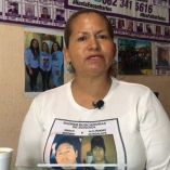 Cecilia Flores, fundadora de Madres Buscadoras de Sonora, aparece en primer plano con expresión seria, al fondo se observan imágenes de personas desaparecidas y fotografías de integrantes del colectivo. La escena refleja la lucha constante por visibilizar la crisis de desapariciones en México.