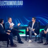 Mesa de especialistas en un foro del Electromovilidad Imagen Summit, con panelistas sentados en escenario y fondo azul del evento, discutiendo los desafíos de la movilidad eléctrica en México, como infraestructura, tecnología y regulación.