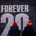 Aficionados miran un mural que homenajea a Diogo Jota, con varias frases que pusieron algunas personas