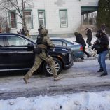 Un agente federal corre hacia los manifestantes que intentan impedir que los vehículos abandonen la escena después de que un conductor de un vehículo recibió un disparo en Minneapolis.