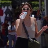 Una mujer bebé agua para mitigar el calor en el Zócalo capitalino.