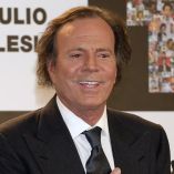 Julio Iglesias posa ante un fondo con su nombre durante un acto público en una imagen de archivo de 2011, vestido con traje oscuro y corbata, en un contexto informativo relacionado con su trayectoria artística.
