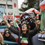 Manifestantes contra el régimen iraní sostienen una bandera de Irán anterior a la revolución de 1979, con los emblemas del león y el sol, y una imagen sin fecha que, según se informa, muestra cadáveres en un lugar no revelado, mientras participan en una manifestación en solidaridad con los manifestantes iraníes y "contra la República Islámica por matar a ciudadanos iraníes" en Yalova, el 16 de enero de 2026.