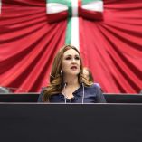 La senadora Geovanna Bañuelos de la Torre habla desde la tribuna del Senado, con el escudo nacional al fondo, durante una sesión en la que denunció la deportación de niñas, niños y adolescentes migrantes sin protección adecuada.