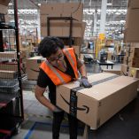 Un trabajador prepara un paquete con el logotipo de Amazon Prime