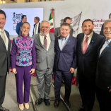 Claudia Sheinbaum acompañada de líderes sindicales durante un evento oficial en la Ciudad de México, con banderas y material institucional al fondo, en un contexto relacionado con temas laborales y organización sindical.