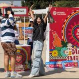 Personas participan en dinámicas de la Lotería Nacional por el 14 de febrero en el Monumento a la Revolución, frente a un módulo decorado con motivos del Día del Amor y la Amistad y promoción del sorteo especial con premio mayor.